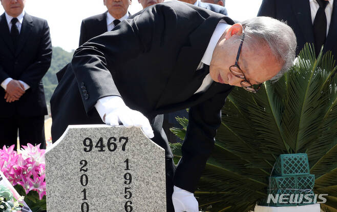 [대전=뉴시스] 강종민 기자 = 이명박 전 대통령이 22일 대전시 유성구 국립대전현충원 천안함 46용사 묘역을 참배한 뒤 묘비를 살펴보고 있다.(공동취재사진) 2023.03.22. photo@newsis.com