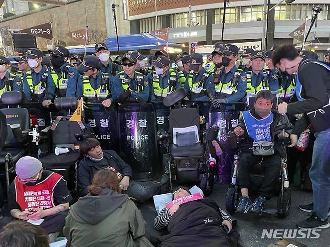 23일 오후 서울 중구 서울시청사 인근 무교로에서 전장연 회원들이 행진 도중 경찰과 대치하고 있다./뉴시스