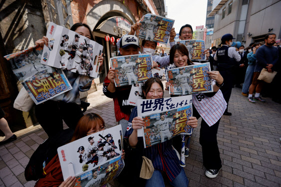 일본의 WBC 우승 소식을 담은 호외를 받은 일본 시민들이 활짝 웃어보이고 있다. 2023년에 흔히 볼 수 없는 광경을 목도한 순간이다. (사진=AFP)