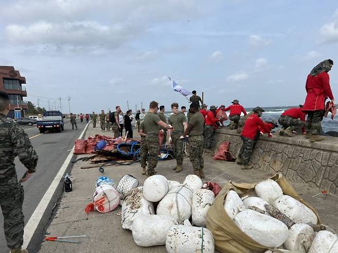 포항향청 회원들과 한·미 해병대원들이 해양쓰레기를 치우고 있다. (포항향청 제공) 2023.03.25