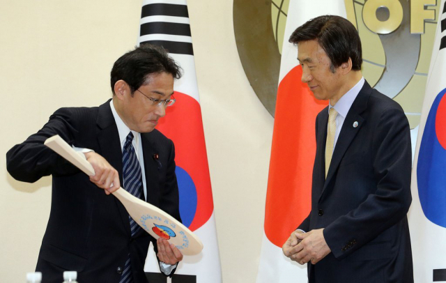 지난 2015년 3월 윤병세 외교부 장관(오른쪽)이 한일외교장관 회담에서 기시다 후미오 당시 일본 외무상으로부터 주걱을 선물 받고 있다. 연합뉴스