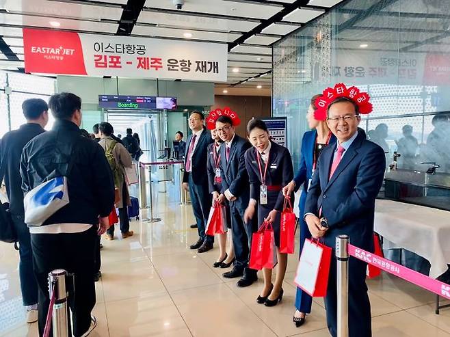 조중석 이스타항공 대표(오른쪽 첫 번째)를 비롯한 임직원들이 26일 김포공항에서 209편 탑승객에게 감사인사를 전하고 선물을 증정하고 있다. ⓒ이스타항공