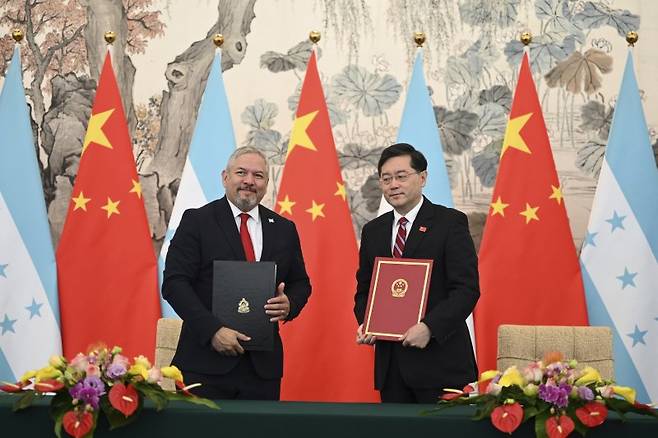 26일 중국 베이징의 댜오위타이 국빈관에서 온두라스의 에두아르도 엔리케 레이나 외무장관(왼쪽)이 중국의 친강 외교부장(장관)과 국교 수립에 서명한 뒤 함께 사진을 찍고 있다.AP뉴시스