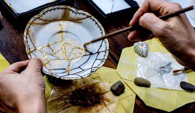 깨진 컵에 옻풀을 발라 붙이고 있다. 조각이 어긋나지 않도록 접착테이프로 고정한다(위). 옻풀이 다 마르면 그 위에 장식용 금분을 발라 수리를 마무리한다.