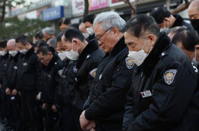 관리자의 '갑질'을 폭로하는 내용의 유서를 남기고 극단적 선택을 한 경비원이 일했던 강남구 대치동 아파트 앞에서 20일 동료 경비원들이 고인을 위한 묵념을 하고 있다. 연합뉴스