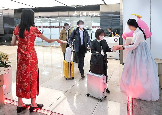 27일 오후 한국공항공사 관계자들이 김포공항에서 김포~베이징·상하이 노선의 운항 재개를 기념해 입국 승객들에게 기념품을 나눠주고 있다.  박형기 기자
