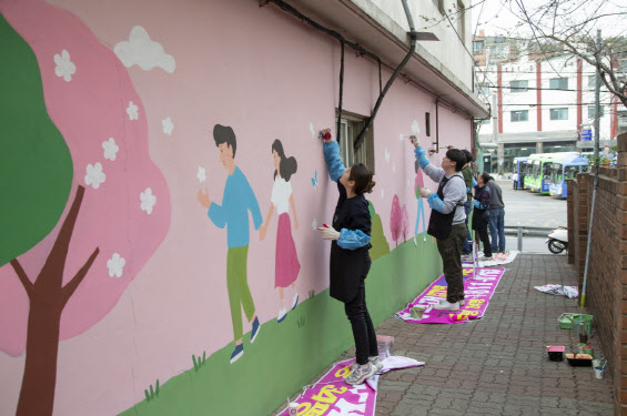JTI코리아 임직원들이 벽화 그리기 봉사를 펼치고 있다.(사진=JTI코리아)