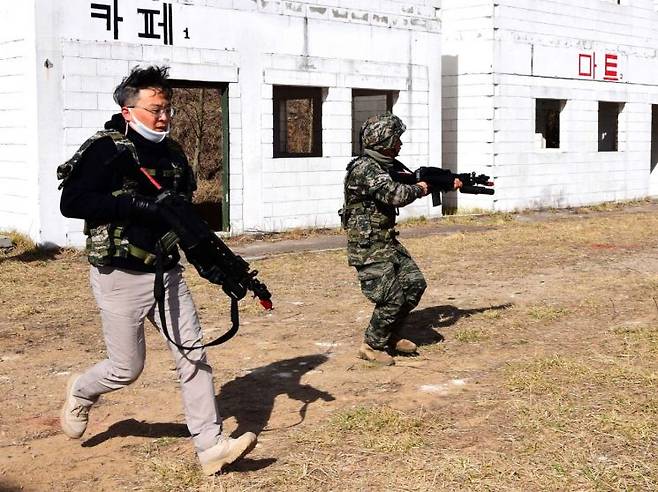 해병대 도시지역 전투교장에서 '마일즈(MILES)' 장비를 착용하고 교전하고 있는 기자.