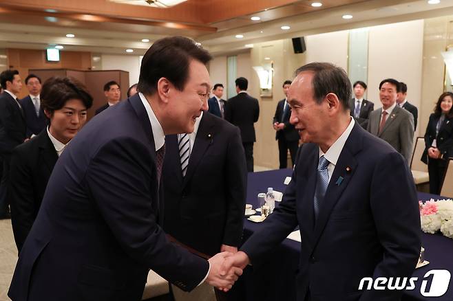 윤석열 대통령이 지난 17일 도쿄 시내 한 호텔에서 열린 일한의원연맹 및 일한친선협회중앙회 접견에서 스가 요시히데 전 총리와 악수하고 있다. (대통령실 제공) 2023.3.19/뉴스1 ⓒ News1 안은나 기자