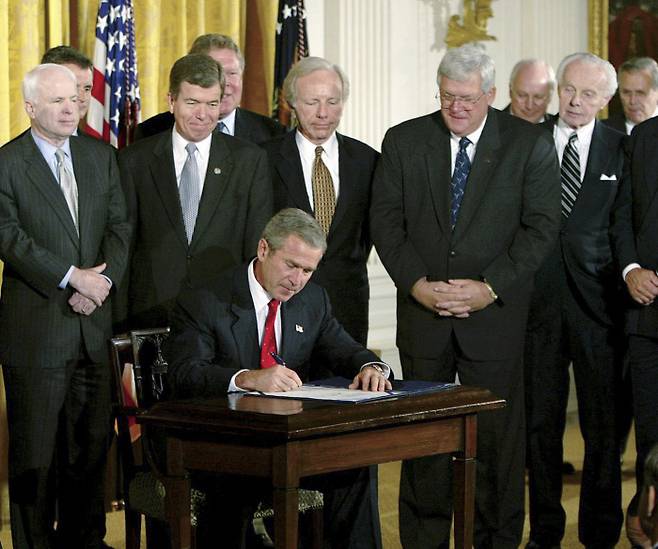 2002년 결의안에 서명하는 부시 조지 W 부시 대통령이 2002년 10월 백악관에서 이라크에 대한 무력 사용을 승인한 의회 결의안에 서명하고 있다. AP연합뉴스