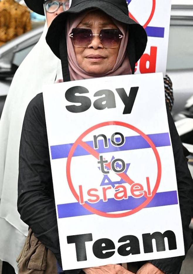 인도네시아 무슬림 여성이 지난 20일 수도 자카르타에서 열린 자국 개최 20세 이하(U-20) 월드컵에 이스라엘의 출전을 반대하는 시위에 포스터를 든 채 참석하고 있다. AFP연합뉴스