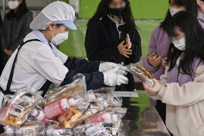 전국학교비정규직연대회의가 총파업에 돌입한 지난해 11월 서울 동작구의 한 중학교에서 학생들이 대체급식으로 빵과 음료를 받고 있다. (사진=사진공동취재단)