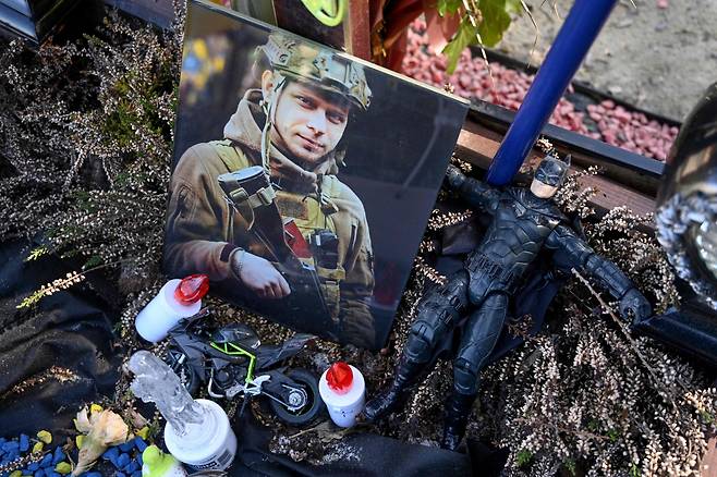 3월 18일 우크라이나 서부 도시 르비우의 리차키우 군인 묘지에 있는 한 병사의 묘에 사진과 어린아이 장남감 등이 놓여 있다./AFP 연합뉴스