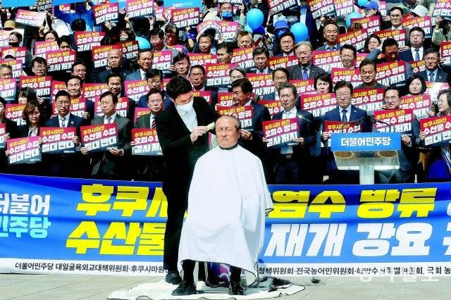 30일 오전 국회 본청 앞 계단에서 열린 더불어민주당의 ‘후쿠시마산 수산물 수입 반대 및 대일 굴욕외교 규탄대회’에서 윤재갑 의원이 삭발을 하고 있다. 김동주 기자 zoo@donga.com