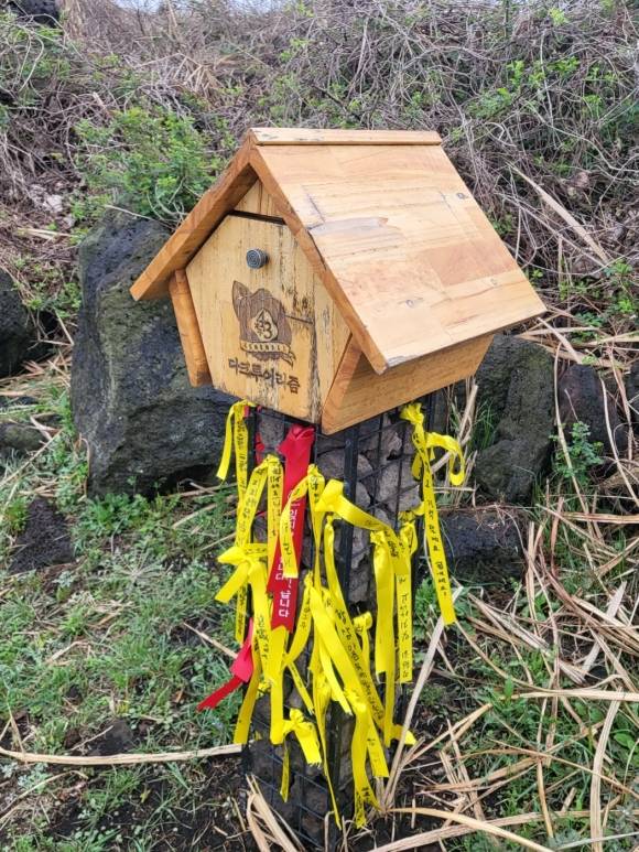 다크투어리즘 푯말에 매달려 있는 희생자들을 기리는 노란 리본들.