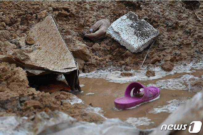 9일(현지시간) 우크라이나 키이우 인근 부차의 러시아 군 민간인 집단 학살 묘지에서 희생자의 손과 슬리퍼가 보이고 있다. ⓒ AFP=뉴스1 ⓒ News1 우동명 기자