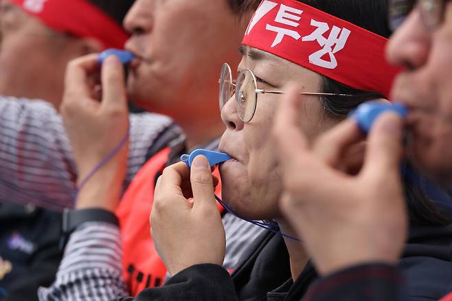 민주노총 집회 참가 노동자들이 25일 오후 4시가 되자 일제히 호루라기를 불고 있다.