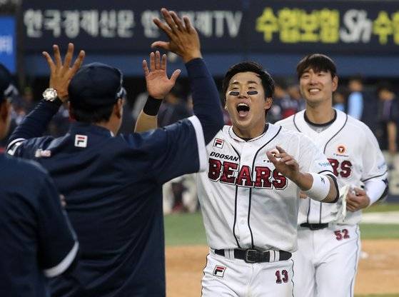 두산 허경민(가운데)과 김재호(오른쪽)가 1일 롯데와의 개막전에서 연장 11회 말 로하스의 끝내기 3점 홈런으로 홈을 밟은 뒤 이승엽 감독을 향해 환호하고 있다. 뉴스1