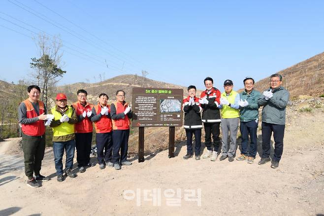 참석자들이 ‘SK 울산 행복의 숲’ 현판 앞에서 기념사진을 촬영하고 있다.(왼쪽 다섯 번째부터 유재영 SK이노베이션 울산CLX 총괄 부사장, 서정욱 울산광역시 행정부시장, 이순걸 울주군수 등)(사진=SK이노베이션 제공)