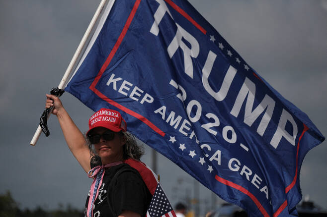 도널드 트럼프 전 미국 대통령의 지지자가 1일(현지시간) 미국 플로리다 팜비치에 있는 마러라고 저택 앞에서 트럼프 전 대통령을 지지하는 깃발을 들고 있다. 로이터연합뉴스