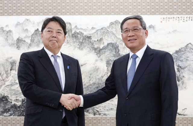 하야시 요시마사 일본 외무상이 리창 중국 총리와 2일 만나 악수하고 있다.로이터연합뉴스