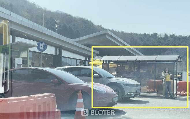 1일 촬영한 가평휴게소 춘천방향 전기차 충전소 모습 사진 노란색 네모 안 흡연구역 내 흡연자가 보인다. (사진=조재환 기자)