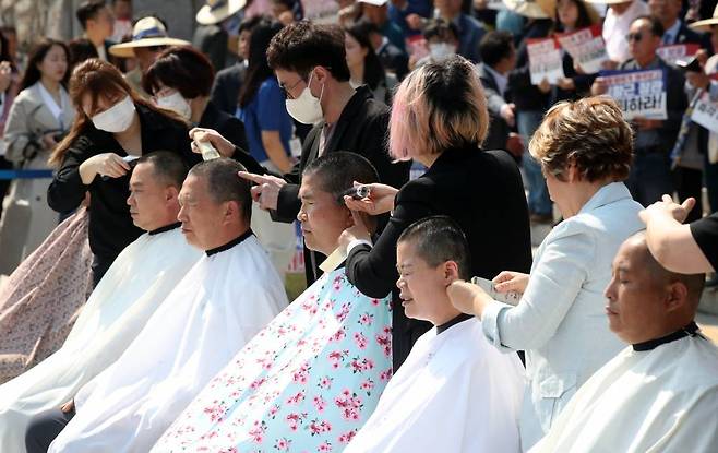 [서울=뉴시스] 고범준 기자 = 신정훈(왼쪽 두번째부터), 이원택 더불어민주당 의원, 농민 등이 3일 오후 서울 여의도 국회 본청 앞 계단에서 열린 쌀값 정상화법 공포 촉구 결의대회에서 삭발을 하고 있다. 2023.04.03.