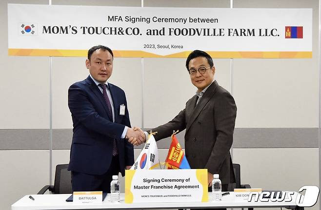 바트툴가(Battulga) 푸드빌 팜(Foodville Farm) 대표이사(좌)와 김동전 맘스터치앤컴퍼니 대표이사(우)가 맘스터치 몽골 마스터 프랜차이즈 계약 체결 직후 기념촬영을 하고 있다.(맘스터치 제공)