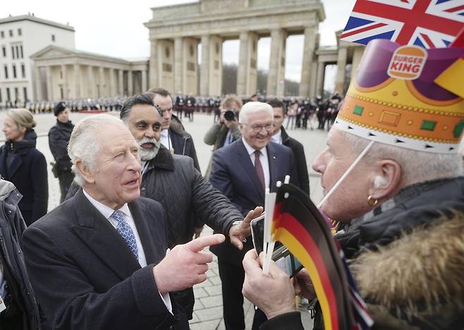 [베를린=AP/뉴시스] 찰스 3세 영국 국왕(왼쪽)이 2023년 3월 29일 수요일 독일 베를린에서 프랑크 발터 슈타인마이어 독일 대통령과 나란히 브란덴부르크 문에서 버거킹 모자를 쓴 지지자에게 인사하고 있다. 2023.04.04 *재판매 및 DB 금지