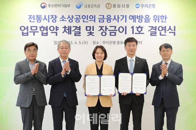 우리은행이 5일 광장시장 인근 소재 종로4가금융센터에서 광장시장과 ‘장금이 1호 결연’을 맺었다. 왼쪽부터 김영재 광장시장 상인총연합회 회장, 임종룡 우리금융그룹 회장, 이영 중소벤처기업부 장관, 이복현 금융감독원장, 정연기 우리은행 중소기업그룹 부행장이 기념촬영을 하고 있다. (사진=우리금융)