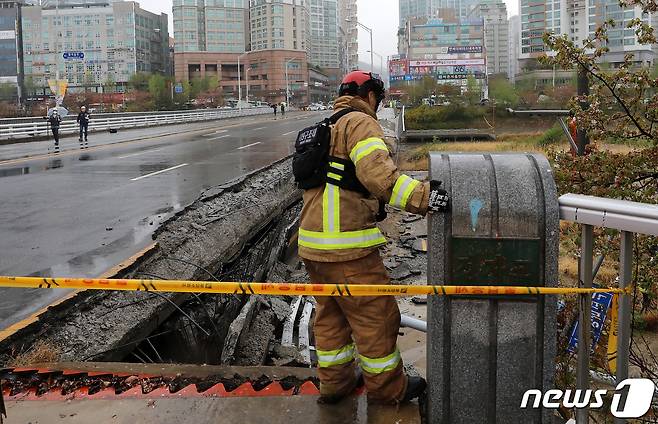 5일 오전 경기 성남시 분당구 정자동 정자교 보행로 일부 구간과 난간이 붕괴되는 사고가 발생, 출동한 소방 구조 대원 등이 분주히 움직이고 있다. 이 사고로 30대 여성 A씨가 숨지고 30대 남성 B씨는 중상을 입어 병원에서 치료 중이다. 2023.4.5/뉴스1 ⓒ News1 김진환 기자