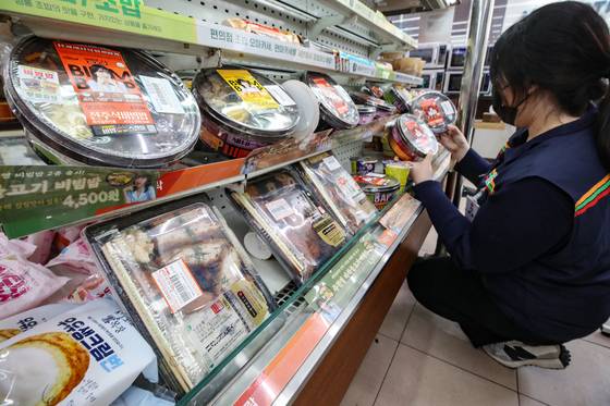 An employee wears a mask during work at a convenience store in central Seoul on March 28. [NEWS1]