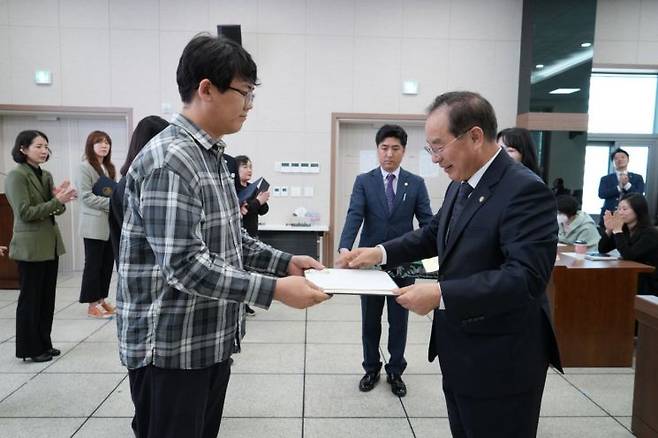 하윤수 부산시교육감(오른쪽)이 학부모기자단 단원에게 위촉장을 수여하고 있다.