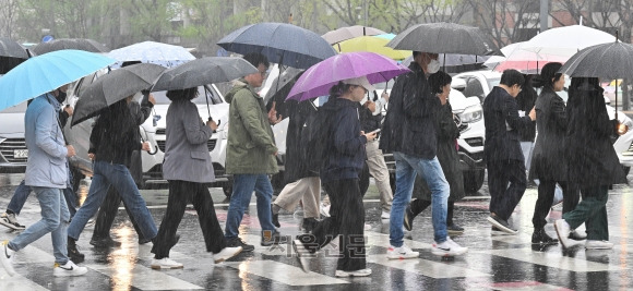 봄비가 내린 5일 오전 서울 종로구 광화문네거리에서 우산을 쓴 시민들이 횡단보도를 건너고 있다. 봄비치고는 많은 양이 내려 경남 일부 지역과 부산 등에 호우특보가 발령됐다. 전국 곳곳에서 일어났던 산불도 모두 꺼졌지만, 심각한 가뭄이 이어진 남부 지역 해갈에는 역부족이었다. 홍윤기 기자