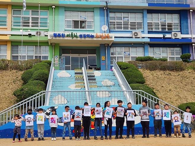 [보은=뉴시스] 안성수 기자 = 회남초등학교 학생들이 7일 '회남초등학교를 지켜주세요!' 피켓을 들고 분교장 개편 반대 캠페인을 펼쳤다. 이 학교는 올해 학생 수가 분교 격하 기준인 21명 미만으로 떨어져 분교장 개편 행정예고가 내려졌다. (사진=보은교육지원청 제공) 2023.4.7. photo@newsis.com *재판매 및 DB 금지