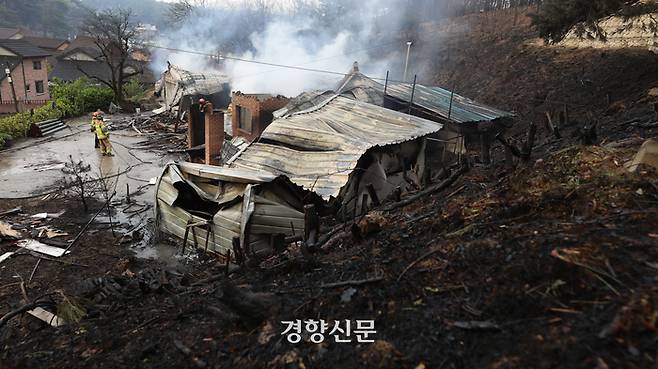 강원 강릉시 난곡동의 한 야산에서 산불이 발생한 11일 화재로 소실된 저동의 한 주택에서 소방관들이 진화 작업을 하고 있다. 강릉|권도현 기자