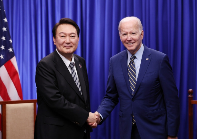 President Yoon Suk Yeol (left) shakes hands with US President Joe Biden at a summit held at a hotel in Phnom Penh, the capital of Cambodia, on Nov. 13 last year. (Yonhap)