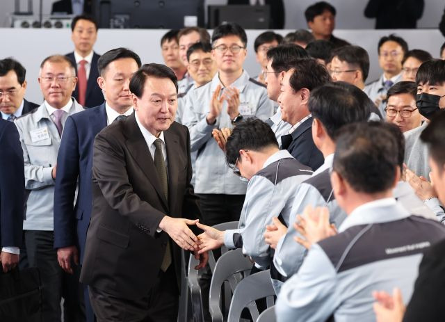 윤석열 대통령이 11일 경기도 화성시 기아 오토랜드 화성에서 열린 전기차 전용공장 기공식에 입장하며 참석자들과 인사하고 있다. 연합뉴스