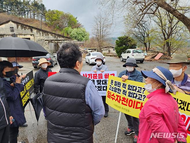 [원주=뉴시스] 이덕화 기자 = 11일 춘천지방법원 원주지원 집행관이 원주지역 서부관문으로 불리는 대명농원 전 시행사인 ㈜엘에스제이 현장사무실 유체동산 일체를 강제 집행한 가운데 담당변호사가 피켓을 들고 현장사무실 앞에서 시위하는 조합원들에게 향후 계획 등을 설명하고 있다. 2023.04.11. wonder8768@newsis.com