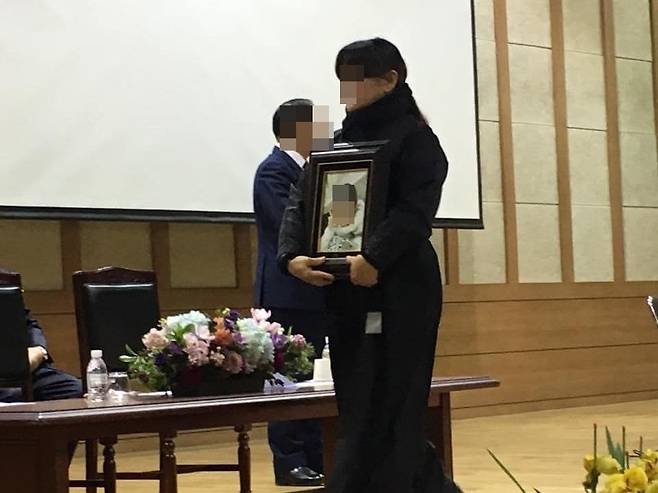 2015년 학교폭력으로 극단적 선택을 한 딸의 영정사진을 들고 2018년 ○○여고 졸업식에 참석한 이씨. /페이스북