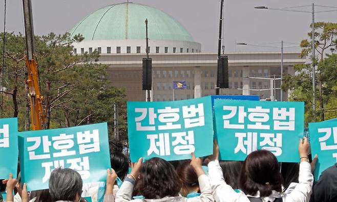 간호법 제정안 국회 본회의 상정을 하루 앞둔 12일 오후 간호법제정촉구 범국민운동본부 주최 집회에 참여한 간호사들이 서울 여의도 국회의사당 앞에서 열린 '간호법 국회 통과 촉구 수요한마당'에서 손피켓을 들고 있다. 뉴시스