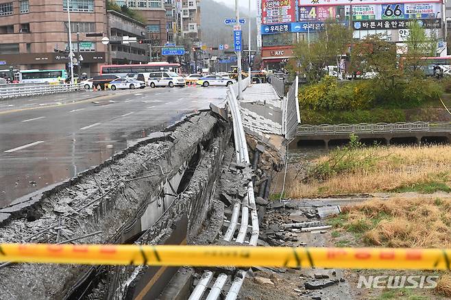 [성남=뉴시스] 김종택 기자 = 5일 오전 경기도 성남시 분당구 정자교 난간이 무너지는 사고가 발생해 소방 대원 등 관계자들이 현장을 수습하고 있다. 이 사고로 교각 가드레일과 이정표 등이 산책로로 쏟아져 30대 여성 1명이 숨지고 30대 남성 1명은 중상을 입어 병원에서 치료 중이다. 2023.04.05. jtk@newsis.com