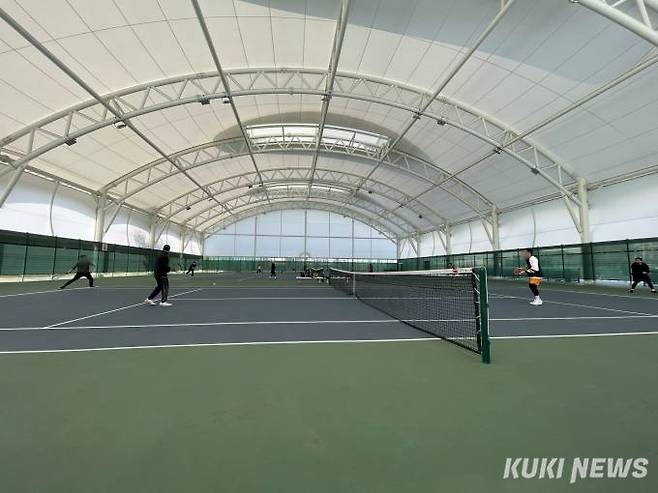 실내 테니스장에서 복식 경기 중인 사람들. 독자 제공