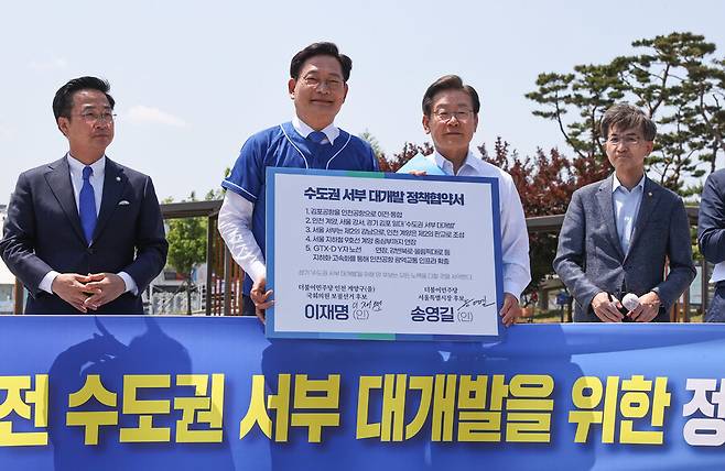 지난 2022년 5월27일 당시 송영길 더불어민주당 서울시장 후보와 이재명 인천 계양을 국회의원 후보가&nbsp; 경기도 김포시 고촌읍 아라 김포여객터미널 아라마린센터 앞 수변광장에서 열린 김포공항 이전 수도권 서부 대개발 정책협약식에서 기념촬영을 하고 있다. 공동취재사진