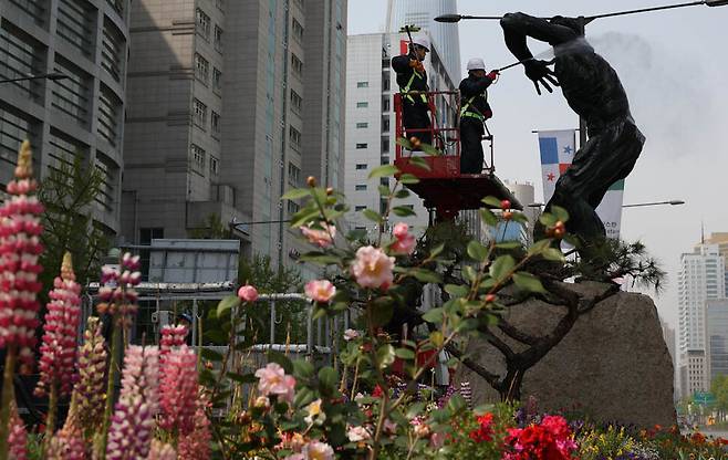 서울 송파구 올림픽로에 있는 88서울올림픽 기념 조형물의 묵은 때를 17일 오전 작업자들이 고압 세척기 등을 이용해 물청소하고 있다. 김정효 기자