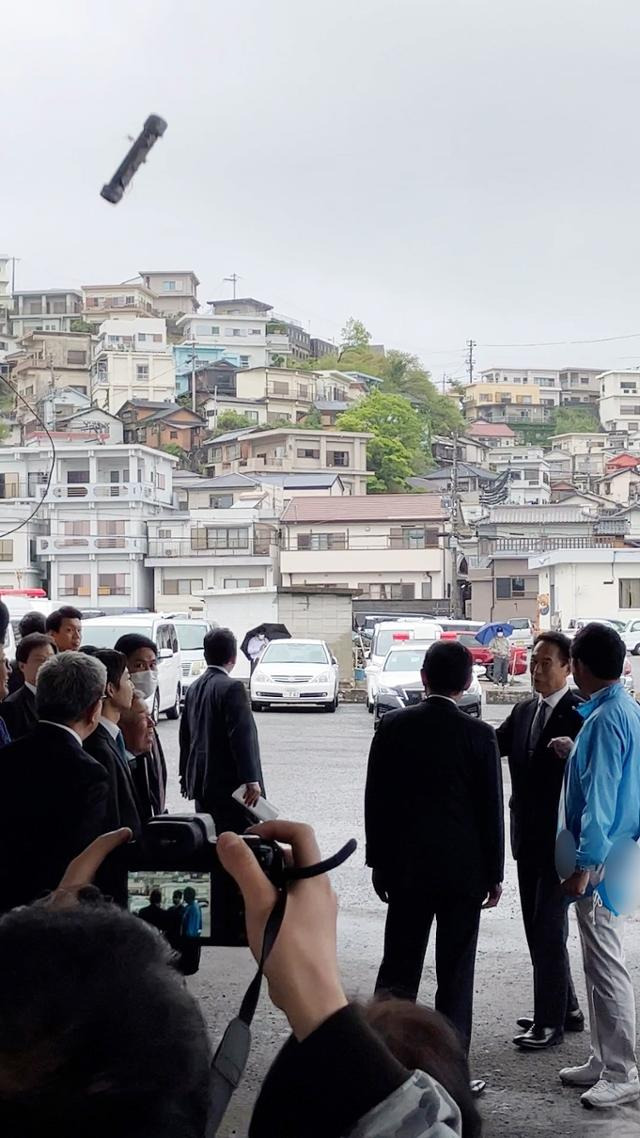 15일 와카야마시의 사이카자키 항구에서 중의원 보궐선거 지원 유세를 하려던 기시다 후미오 일본 총리를 향해 던져진 폭발물이 현장을 촬영하고 있던 참석자의 스마트폰에 잡혔다. 제보자 제공. EPA 지지 연합뉴스