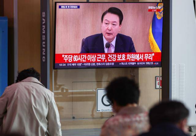 지난달 21일 오전 서울역 대합실에서 시민들이 생중계로 진행되는 국무회의 방송을 지켜보고 있다. 이날 국무회의에서 윤석열 대통령은 근로시간 개편안과 관련해 "주 60시간 이상 근무는 무리"라는 의견을 냈다. 연합뉴스