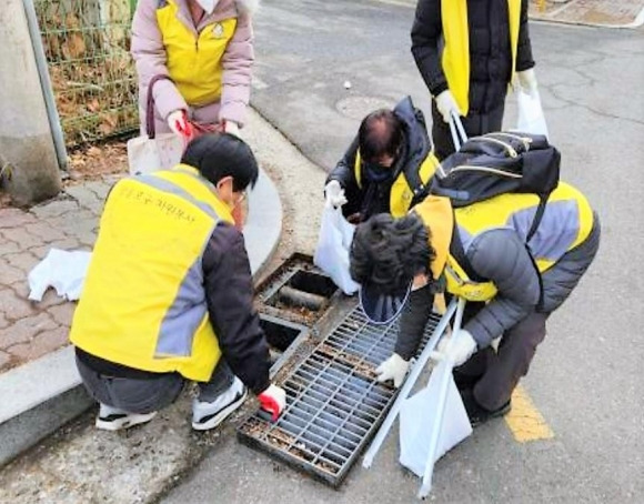 영등포구 관계자들과 자원봉사자들이 빗물받이 안의 나뭇잎 등을 제거하고 있다. 영등포구 제공