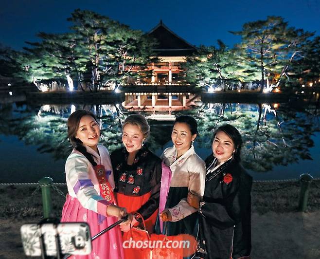 지난 2020년 한복을 입고 ‘경복궁 별빛야행’에 참가한 관람객들이 경회루를 배경으로 셀카를 찍으며 즐거워하고 있다. 조명을 받은 2층 누각과 나무가 연못에 그대로 비치는 이곳은 별빛야행의 ‘베스트 뷰’로 꼽힌다. /박상훈 기자