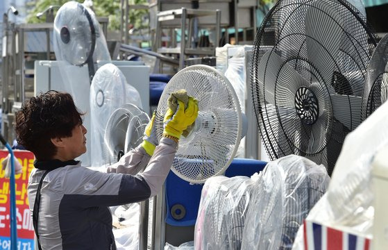 초여름 날씨를 보인 19일 대구 북구 칠성시장 중고 가전제품 상점에서 한 상인이 선풍기의 묵은 먼지를 닦아내고 있다. 뉴시스